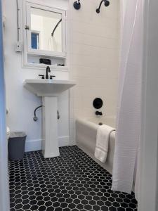 a white bathroom with a sink and a bath tub at Modern Unit 313 at The George in Klamath Falls