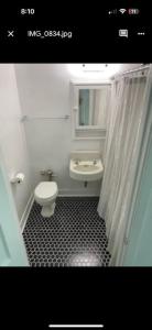 a bathroom with a sink and a toilet and a mirror at Beautiful Apartment 307 in a 100 year old building in Klamath Falls
