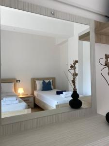 a bedroom with a bed and a large mirror at Villa White in Ksamil