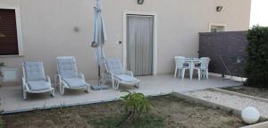 a patio with chairs and a table and an umbrella at B&B L'EDEN DI CAPO BIANCO in Montallegro