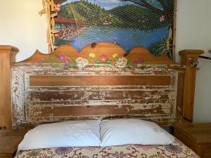 a headboard of a bed with a painting on the wall at Hostal San Fransiskuni in Morelia