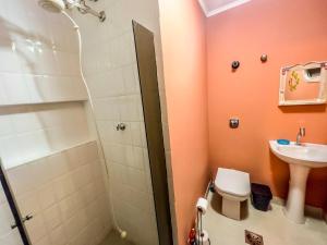 a bathroom with a shower and a toilet and a sink at R6 · Uma obra de arte na sua praia in Guarujá +12 photos