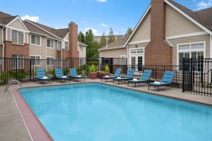 a swimming pool with chairs and a fence at Residence Inn Portland Hillsboro in Hillsboro