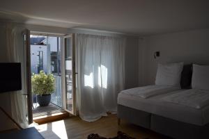 Un dormitorio con una cama y una ventana con balcón. en Altstadtperle, en Constanza