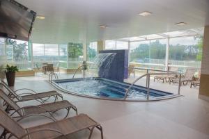 a swimming pool with a water fountain in a building at Hotel Senac Grogotó in Barbacena