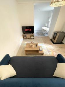 een woonkamer met een blauwe bank en een tv bij Le Loft d'Azur - Cozy - Netflix in Fontainebleau