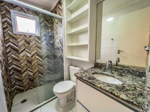 a bathroom with a toilet and a sink at R7 Conforto total com piscina in Guarujá +23 photos