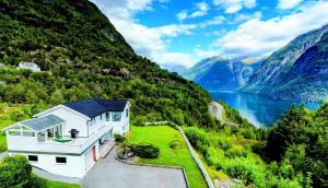 a house in the mountains with a view of a lake at Fjellhagen - Geirangerfjord view in Hellesylt