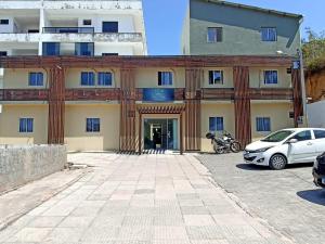 a building with a car parked in front of it at Pousada Villa Costeira in Maragogi