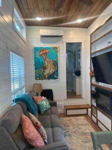 a living room with a couch and a flat screen tv at Tiny Home w Great Bay Views Pets Near Eglin Beach in Freeport