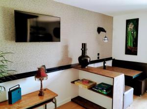 a living room with a table and a shelf at Le Lodge Merlin Studio 2 personnes in Barraux