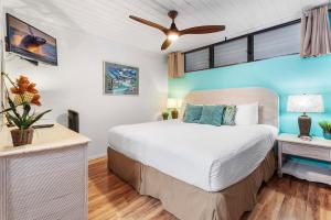 a bedroom with a bed and a ceiling fan at Kona Reef A36 in Kailua-Kona +36 photos