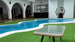 El ParaísoHotel H4的建筑物中间有一张椅子的游泳池