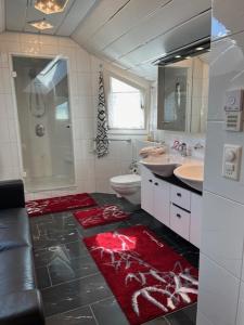 a bathroom with two sinks a toilet and a shower at Ruhige Zimmer im Grünen und Studio im Naherholungsgebiet in Sigigen +31 photos