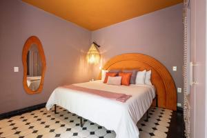 a bedroom with a large bed and a mirror at HOLT Art Deco Retreat in Vibrant 3 Bedroom Villa in San Miguel de Allende