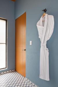 a dress hanging on a wall next to a door at HOLT Art Deco Retreat in Vibrant 3 Bedroom Villa in San Miguel de Allende +57 photos