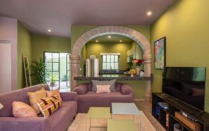 a living room with a couch and a tv at HOLT Art Deco Retreat in Vibrant 3 Bedroom Villa in San Miguel de Allende