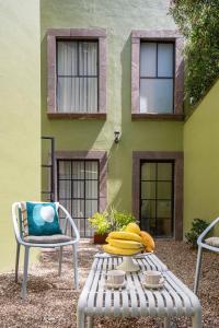 a table with bananas on it next to a building at HOLT Art Deco Retreat in Vibrant 3 Bedroom Villa in San Miguel de Allende