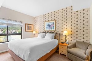 コッパー・マウンテンにあるGreens at Copper 318 by Summit County Mountain Retreatsのベッドと椅子のある寝室