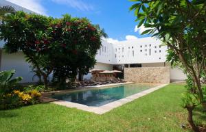 a pool in front of a building with trees and grass at Casa Loreto 1893 in Mérida