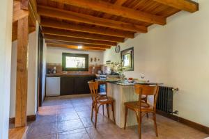 a kitchen with wooden ceilings and a table and chairs at Casas Huron!! in San Carlos de Bariloche