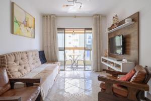 a living room with a couch and a tv at Apto em otima localização em Meia Praia EIO6031 in Meia Praia