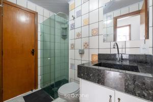 a bathroom with a sink and a toilet and a mirror at Apto em otima localização em Meia Praia EIO6031 in Meia Praia +11 photos