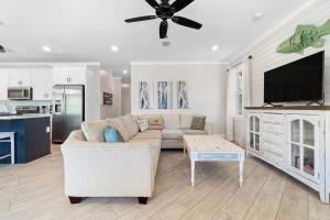 a living room with a couch and a flat screen tv at Beach Please in Gulf Shores