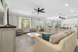 a living room with a couch and a kitchen at Beach Please in Gulf Shores