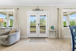 a living room with a chair and a door at Beach Please in Gulf Shores
