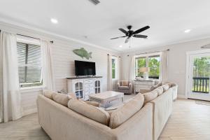 a living room with a couch and a flat screen tv at Beach Please in Gulf Shores