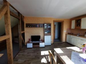 a kitchen with a table and a tv in a room at Holiday apartment mountain idyll in Hänischmühle +18 photos