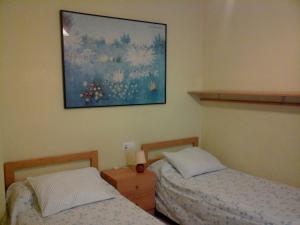 een slaapkamer met twee bedden en een schilderij aan de muur bij Apartament Fira in Hospitalet de Llobregat