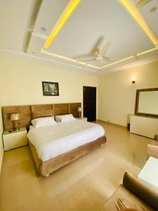 a bedroom with a large bed and a couch at Dream Inn Guest House Islamabad in Islamabad