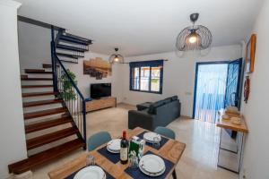 a living room with a dining table and a staircase at Casa azul Agaete in Las Palmas de Gran Canaria