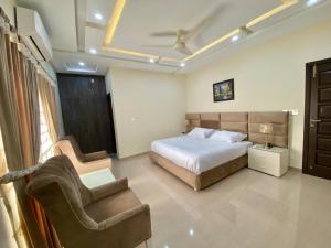 a bedroom with a bed and a couch and a chair at Dream Inn Guest House Islamabad in Islamabad