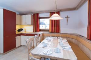 ein Esszimmer mit einem Tisch und einer Küche in der Unterkunft Appartement Landhaus KERSCHDORFER in Kaltenbach