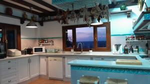 a kitchen with white cabinets and a large window at Az-zait in Aznalcázar