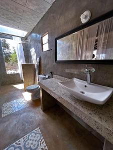 a bathroom with a sink and a toilet and a mirror at Chalés sol e luar in Serra do Cipo