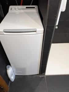 a small white refrigerator in a corner of a room at La Molina Tranquil Escape in La Molina