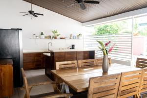 a dining room with a wooden table and chairs at Hotel Por Qué No in Uvita