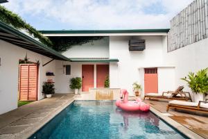 - une piscine avec un flamant gonflable rose dans une maison dans l'établissement Hotel Por Qué No, à Uvita
