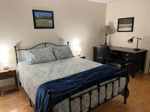 una camera da letto con un letto e una scrivania con una sedia di True Blue Spacious Condo on golf course! a True Blue Altre 17 foto