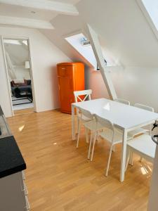 a dining room with a white table and chairs at Cozy 2-room Apartment in Aarhus