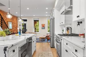 a kitchen with white counter tops and appliances at Central DC 5-BR Townhome - Walk to METRO-rail in Washington, D.C.