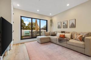 a living room with a large couch and a large window at Central DC 5-BR Townhome - Walk to METRO-rail in Washington, D.C.