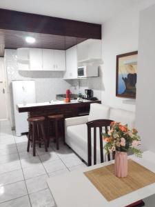 a kitchen and living room with a couch and a table at Flat na Praia do Farol da Barra in Salvador