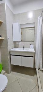 a bathroom with a white sink and a toilet at Appartement Gardenia, Cozy et bien situé in El Balia +39 photos
