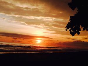 a sunset on the beach with the sun in the sky at Dreamy Contentment in Matapalo