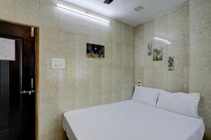 a bedroom with a white bed in a room at Hotel O DREAMZZ INN in Nagpur